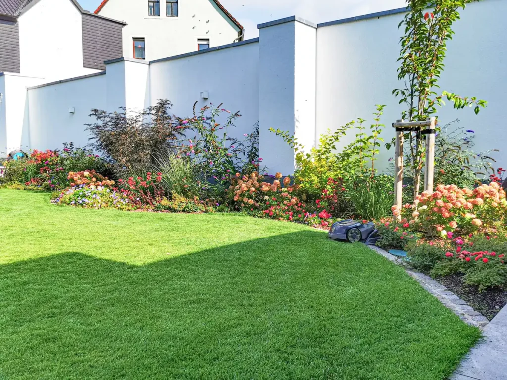 rundum Galabau GmbH – Gartenbereich mit angelegtem Beet und gepflegter Rasenfläche
