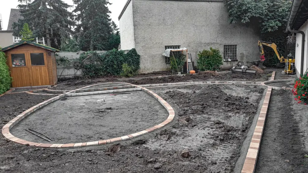rundum Galabau GmbH – Fachgerechte Bodenvorbereitung mit anschließender Pflasterung aus Natursteinplatten für Weg