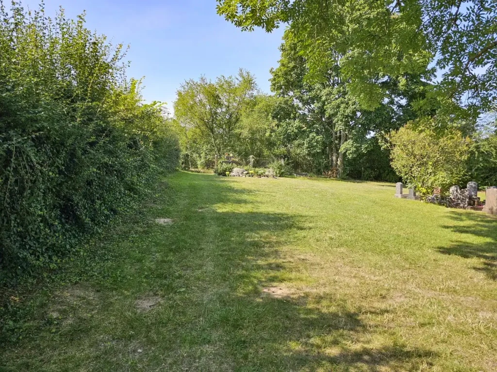 rundum Galabau GmbH – Grüne, gepflegte Rasenfläche auf dem Friedhof, fachgerecht angelegt und gepflegt