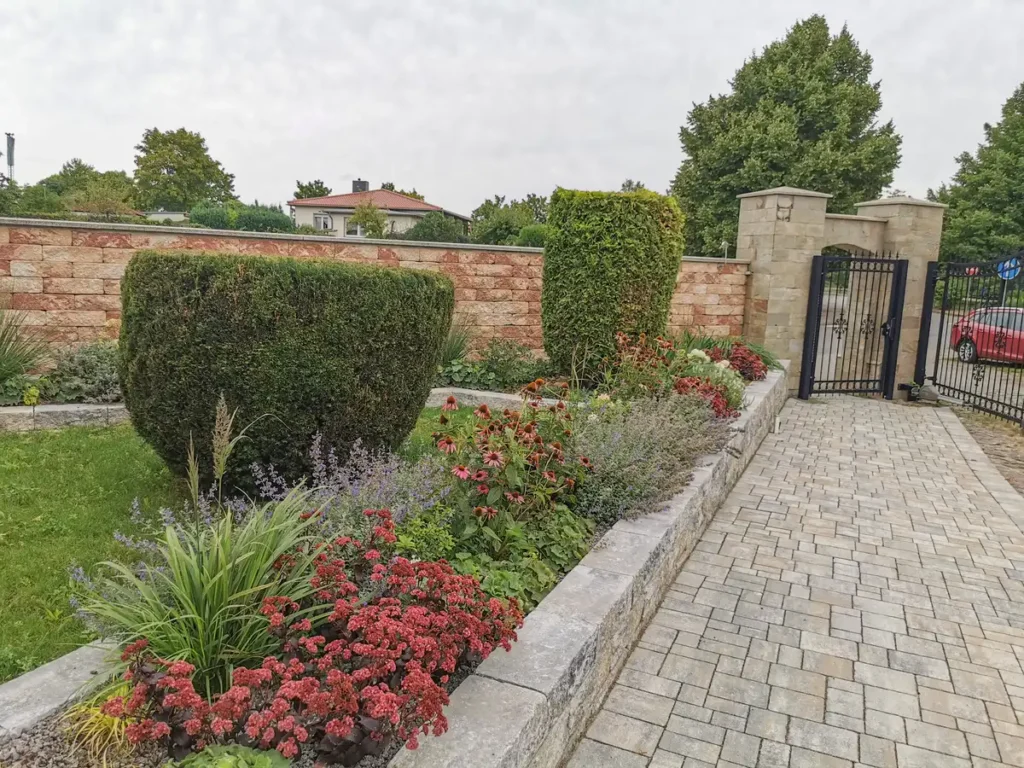 rundum Galabau GmbH – Beet und Weg im Garten mit fachgerechter Bepflanzung aus Blumen, harmonisch gestaltet